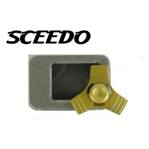 10653 - Computech-Solutions Gold tri-spinner fidget spinner resting on a gray metal case with a black window, SCEEDO logo visible above.