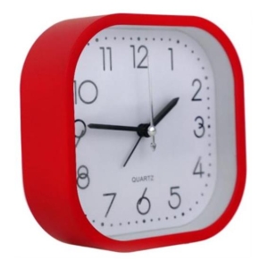 Red square alarm clock with white face showing about 9:00 on a light background