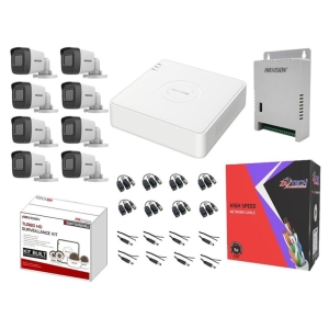 Eight white CCTV cameras with a white network video recorder and Hikvision kits with cables and mounting accessories laid out.