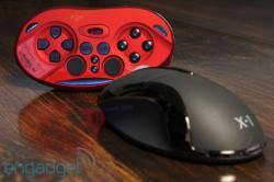 PM-0101X1-DZA - Computech-Solutions Red game controller with blue buttons placed next to a black wireless mouse on a wooden desk.