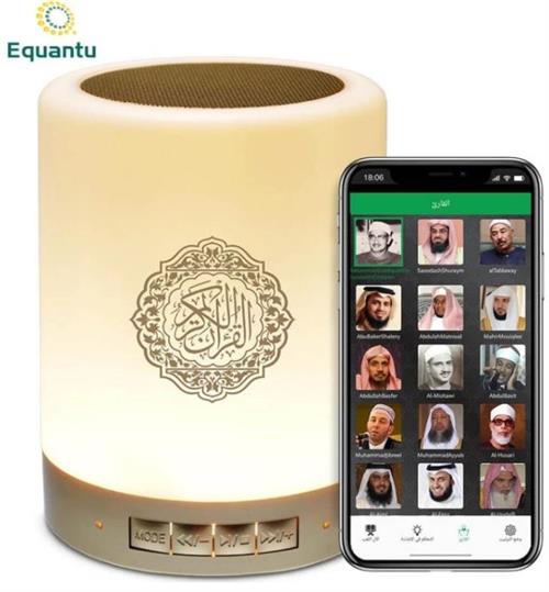 SQ-122 - Computech-Solutions Cream-colored cylindrical speaker with a decorative Arabic emblem, placed beside a smartphone showing a grid of reciters in a mobile app.
