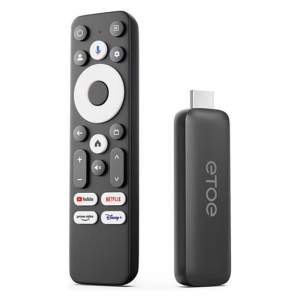 Black TV remote with circular navigation pad and app shortcut buttons (YouTube, Netflix, Prime Video, Disney+) beside a small streaming dongle used for streaming services.