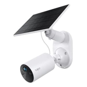 White outdoor security camera with a mounted solar panel on the wall. The solar panel charges the camera system as part of a solar-powered setup.