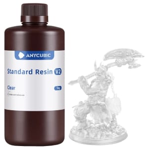 Brown bottle of Anycubic Standard Resin V2 (1 kg) with a white label, beside a translucent crystal miniature on a white background.
